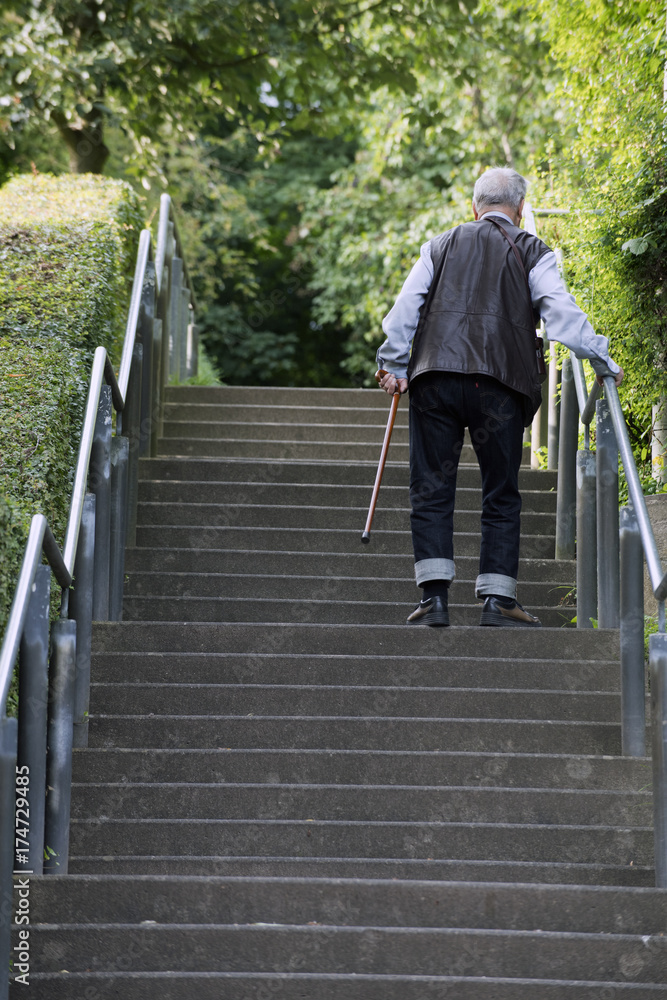 ein alter mann mit stock geht eine treppe hinauf