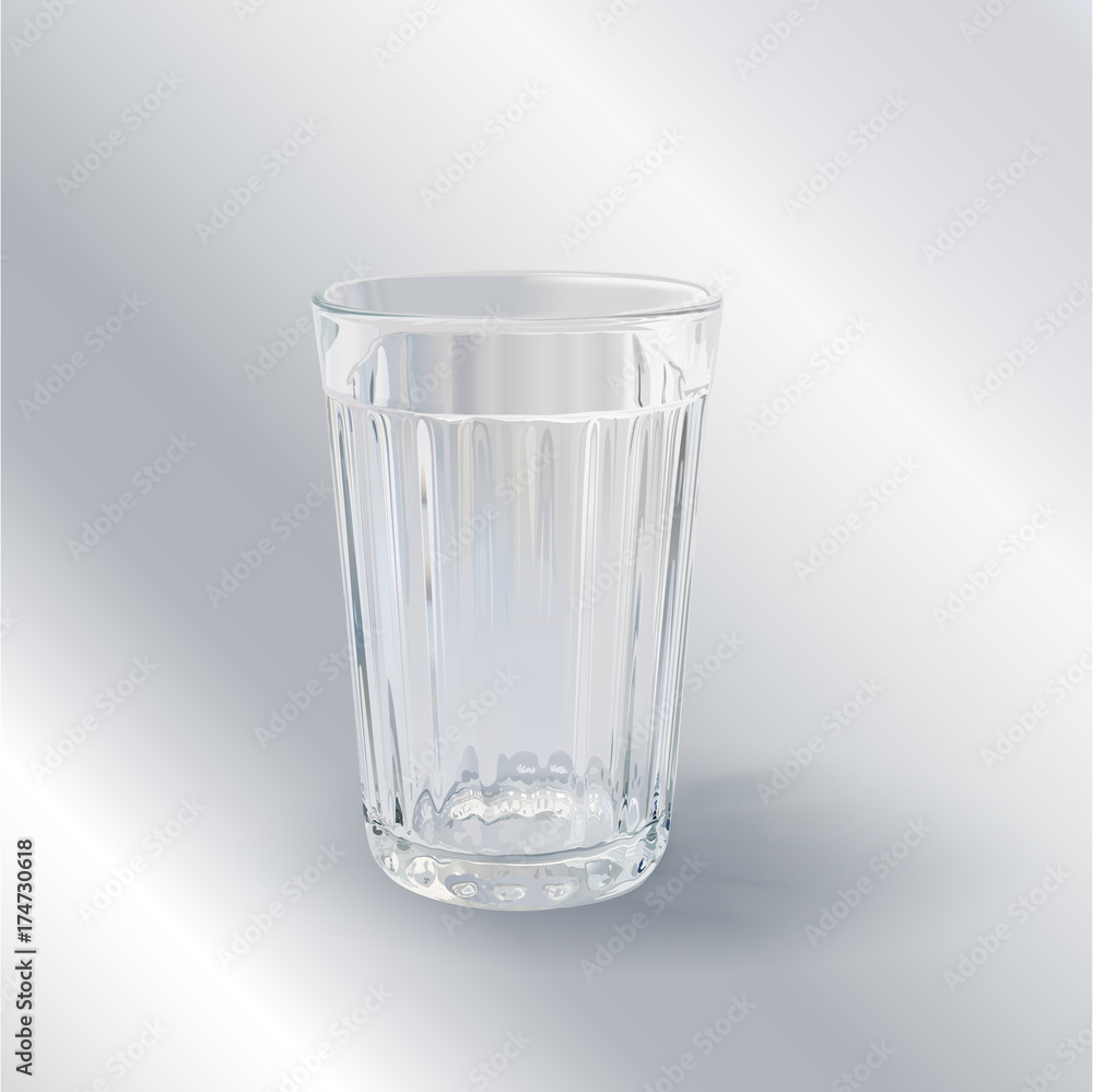 one transparent empty faceted glass on a gray background one transparent empty faceted glass on a gray background