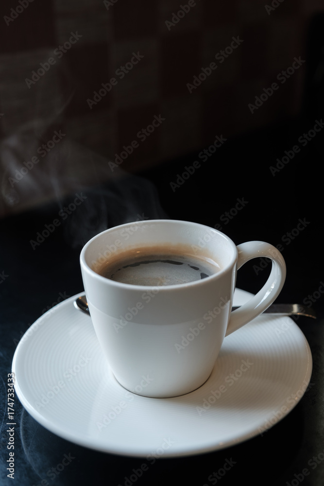 Coffee cup on black marble table in cafe