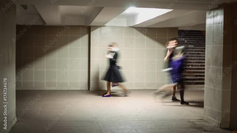 People walking in underpass. Time lapse in grey colors and square perspective People walking in underpass. Time lapse in grey colors and square perspective