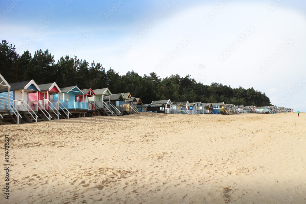 Row of beach huts on an empty, sandy Norfolk beach