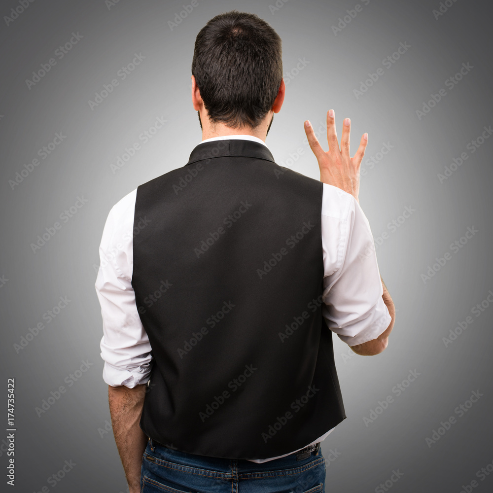 Cool man counting four on grey background Cool man counting four on grey background