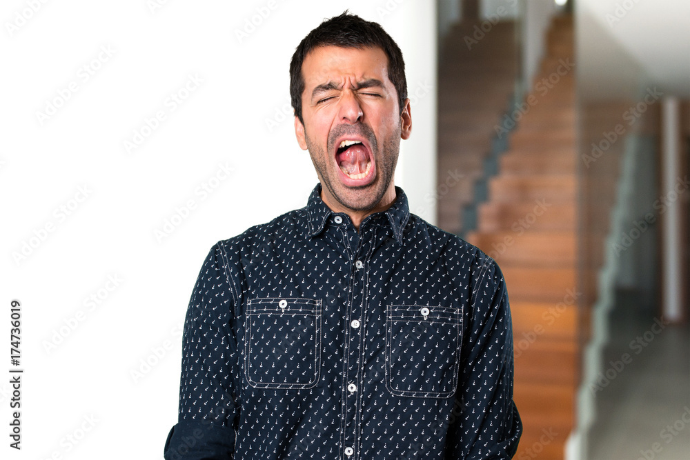 Brunette man yawning inside house Brunette man yawning inside house