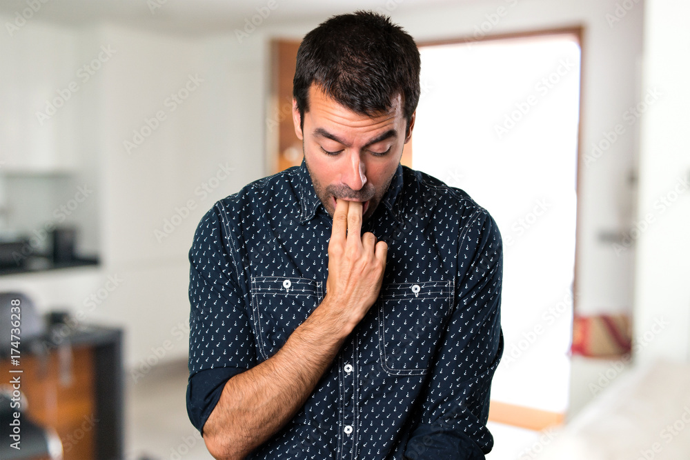 Brunette man making vomiting gesture inside house Brunette man making vomiting gesture inside house