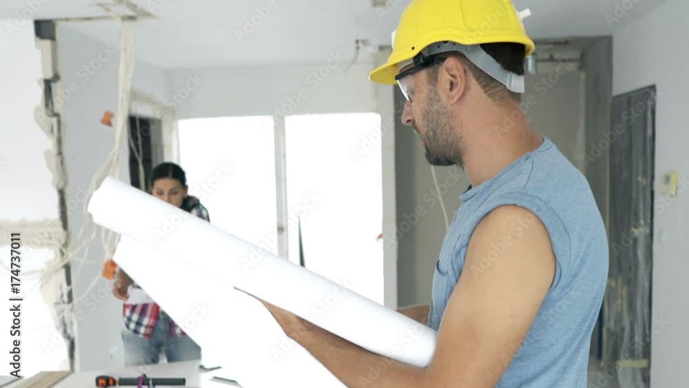 Young couple with blueprints fighting at their new home
Young couple with blueprints fighting at their new home