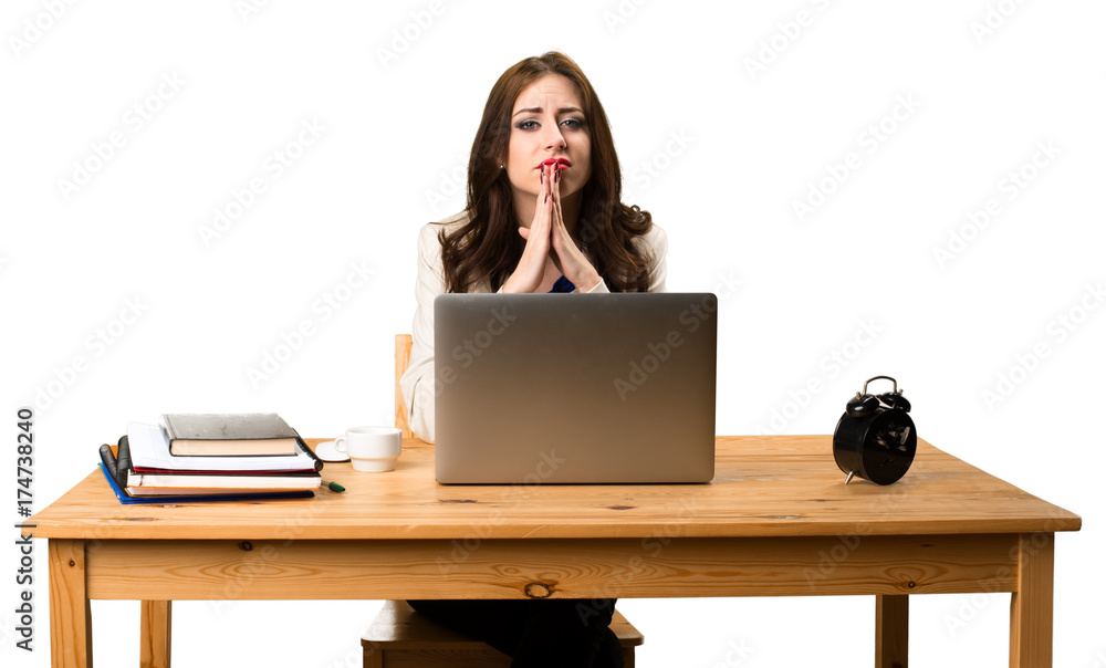 Business woman working with her laptop and pleading Business woman working with her laptop and pleading