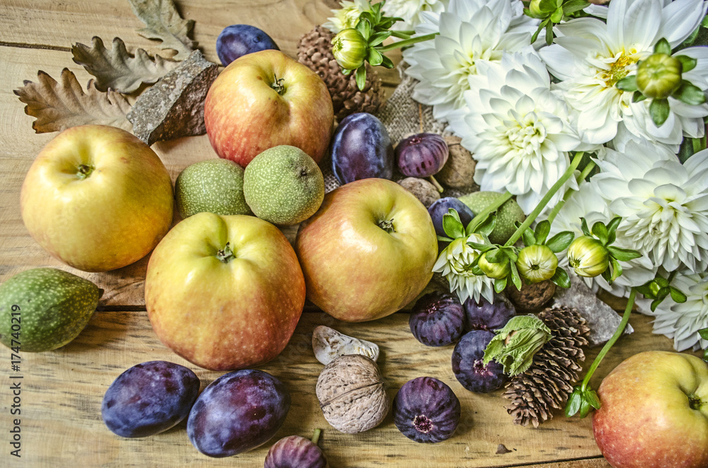 Bouquet of  white dahlias with apples, green nuts,prunes and figs on wooden boards


