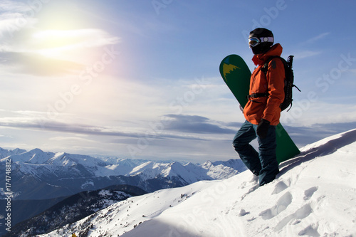 Small snowboarder on blue sky backdrop.