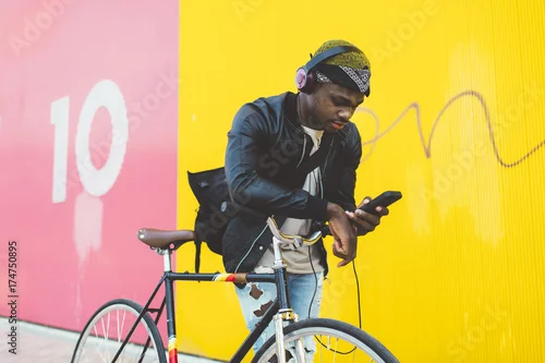 Obraz Afrykański młody człowiek z naprawionym przekładnia bicyklem.