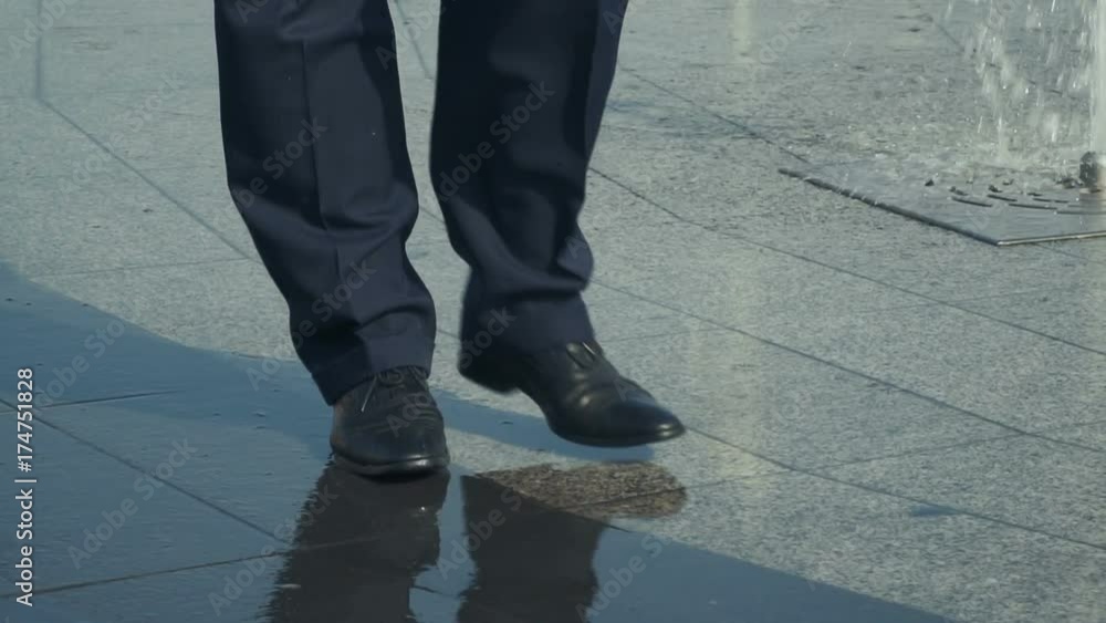 Man walks near the fountain, wet shoes, close-up Man walks near the fountain, wet shoes, close-up