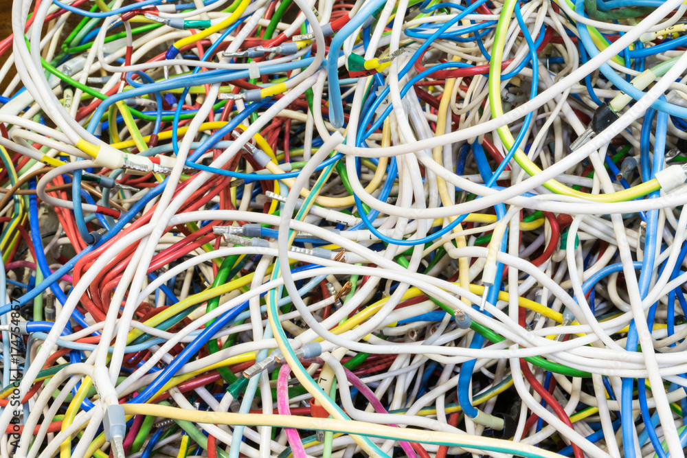 The bunch of electric wires of different colors are very much intertwined. On tangled wires is wire-end ferrules and markings. Chaos, confusion, tangle. The bunch of electric wires of different colors are very much intertwined. On tangled wires is wire-end ferrules and markings. Chaos, confusion, tangle.