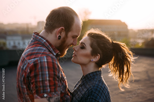 Tender couple cuddle. Relationships background. Passion young people together on roof closeup, atmospheric backlight with focus on foreground, love on top of the world concept