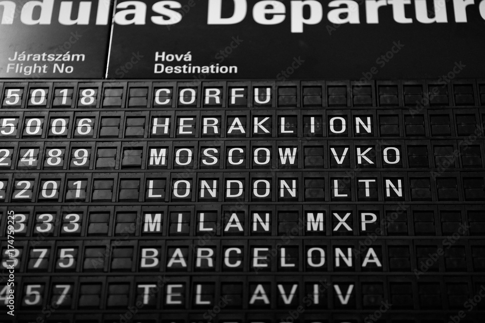 Obraz premium Departures board at the airport. Flight information mechanical timetable. Split flap mechanical departures board. Flight schedule