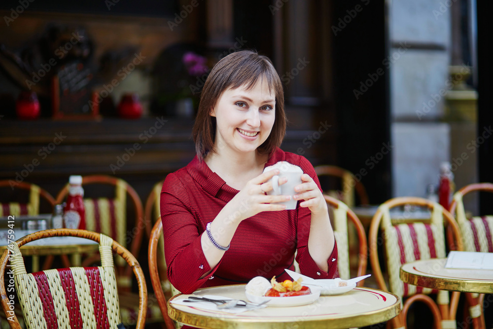 Woman drinking coffee in Parisian outdoor cafe