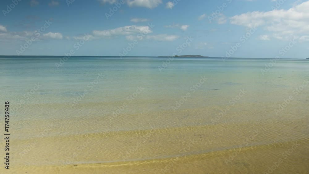 A wide idyllic shot of the beach. The water of the beach is clear. Small islands are seen from a far. A wide idyllic shot of the beach. The water of the beach is clear. Small islands are seen from a far.