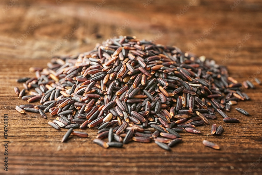 Heap of wild rice on wooden background