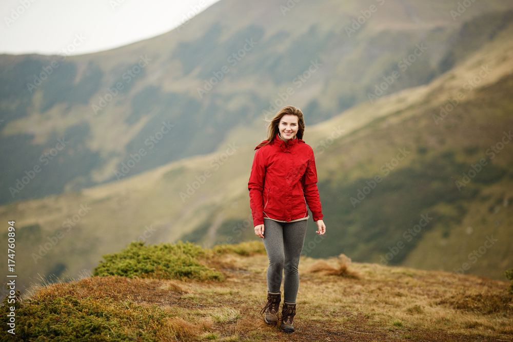 Shot of a young woman looking at the landscape while hiking in the mountains. Girl tourist in mountain. Recreation fitness and healthy lifestyle outdoors in beautiful nature