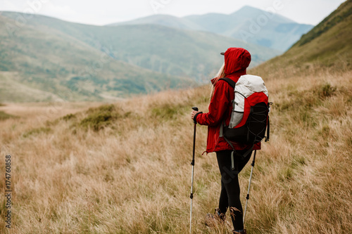 Trekking - woman hiking in mountains on a calm summer day. Woman hiker descending a mountain trail in summer. Travel concept adventure active vacations outdoor aerial view