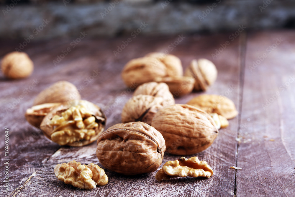 Walnut kernels and whole walnuts on rustic old wooden table. Walnut kernels and whole walnuts on rustic old wooden table.