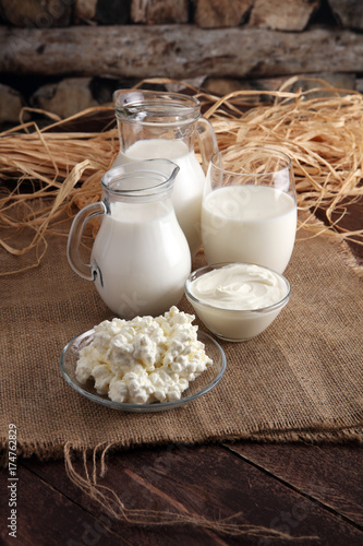 milk products. tasty healthy dairy products on a table on. sour cream in a bowl  cottage cheese bowl  cream in a a bank and milk jar  glass bottle and in a glass