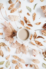 Coffee with milk and dry autumn leaves on white background. Flat lay, top view fall concept.