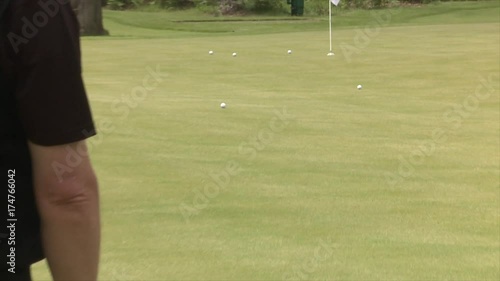 Chipping onto a golf practice green using aiming rods