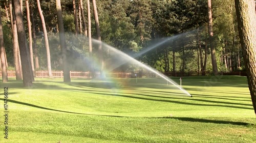 Sprinklers on a golf course cause a rainbow effect