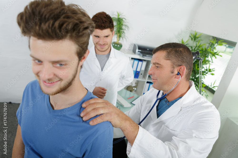 smiling students of physiotherapist and young patient smiling students of physiotherapist and young patient