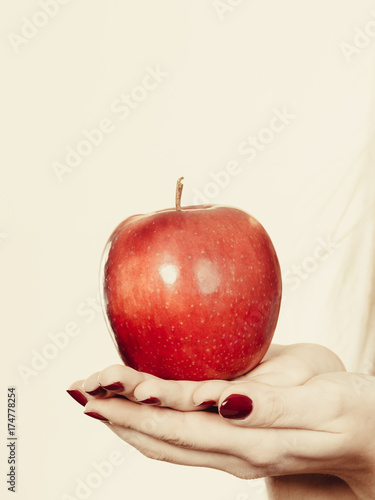 Woman hand holding red apple, healthy food concept
