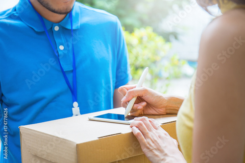 Φωτογραφία woman accepting receive a delivery of boxes from delivery asian man, sign and re