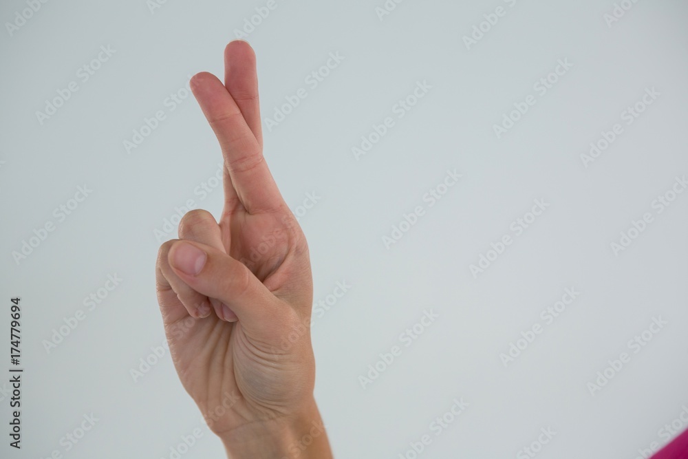 Cropped hand of woman showing crossed fingers Cropped hand of woman showing crossed fingers