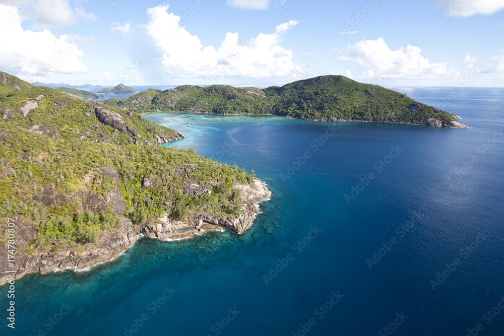 The coast of Baie aux Chagrin with the typical granite rocks of the Seychelles, at the back the Pointe Matoopa, Mahe Island, Seychelles, Indian Ocean, Africa