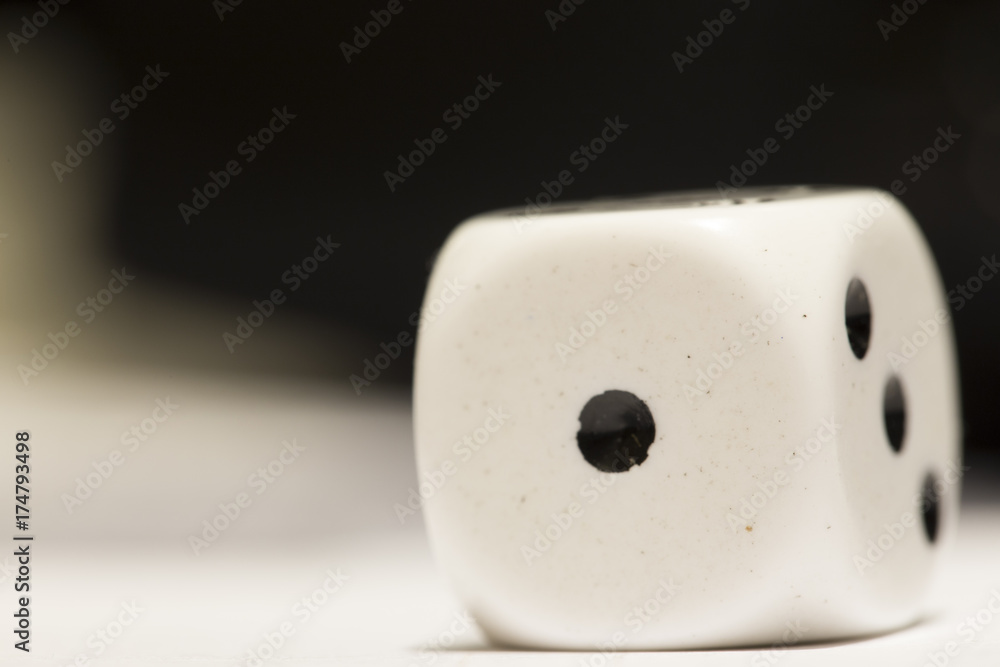 White six-sided die showing the number one. White six-sided die showing the number one.