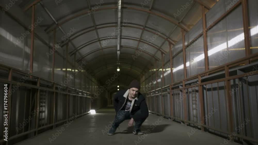 Guy squats on the floor and looks at the camera Guy squats on the floor and looks at the camera