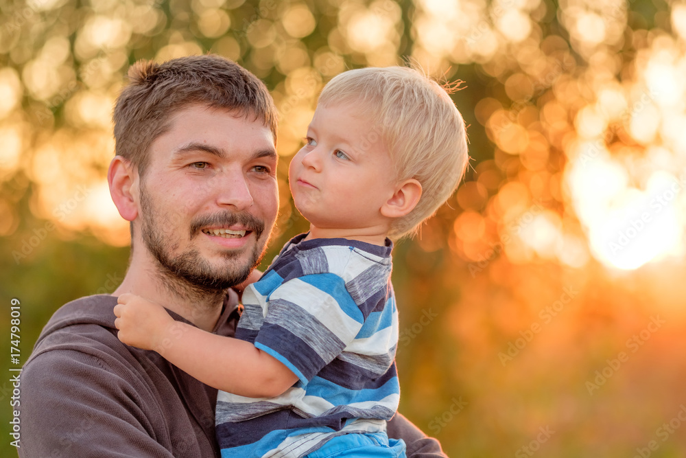 Father and son outdoor portrait in sunset sunlight Father and son outdoor portrait in sunset sunlight