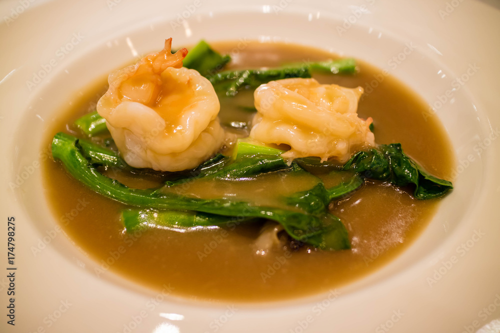 Fried noodle with prawn, chinese kale and gravy on white plate Fried noodle with prawn, chinese kale and gravy on white plate