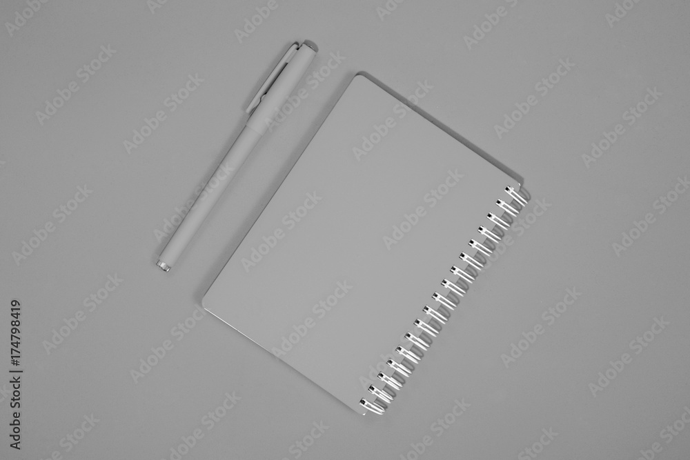 Gray notepad and pen on a gray background. Gray notepad and pen on a gray background.