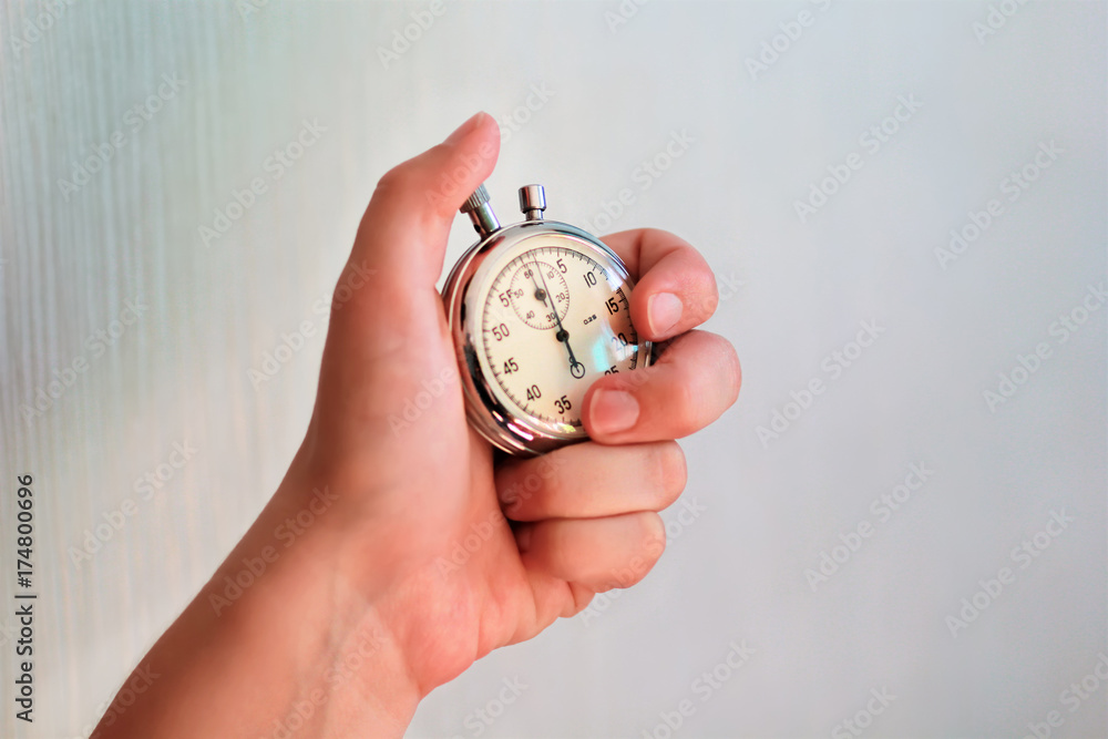 Hand holding a stopwatch and pressing the button to note the time. Hand holding a stopwatch and pressing the button to note the time.