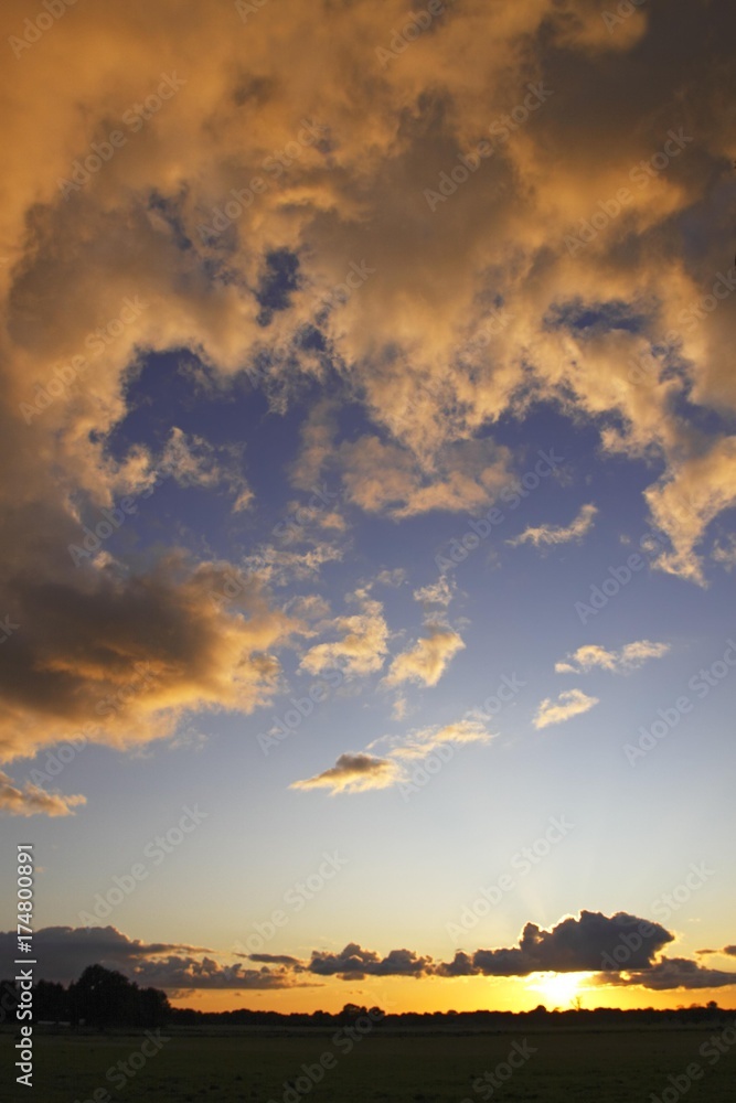 Dramatic sky with clouds illuminated from below by the late evening sun at sunset, landscape in Oberalsterniederung Nature Reserve, Tangstedt, Schleswig-Holstein, Germany, Europe Dramatic sky with clouds illuminated from below by the late evening sun at sunset, landscape in Oberalsterniederung Nature Reserve, Tangstedt, Schleswig-Holstein, Germany, Europe