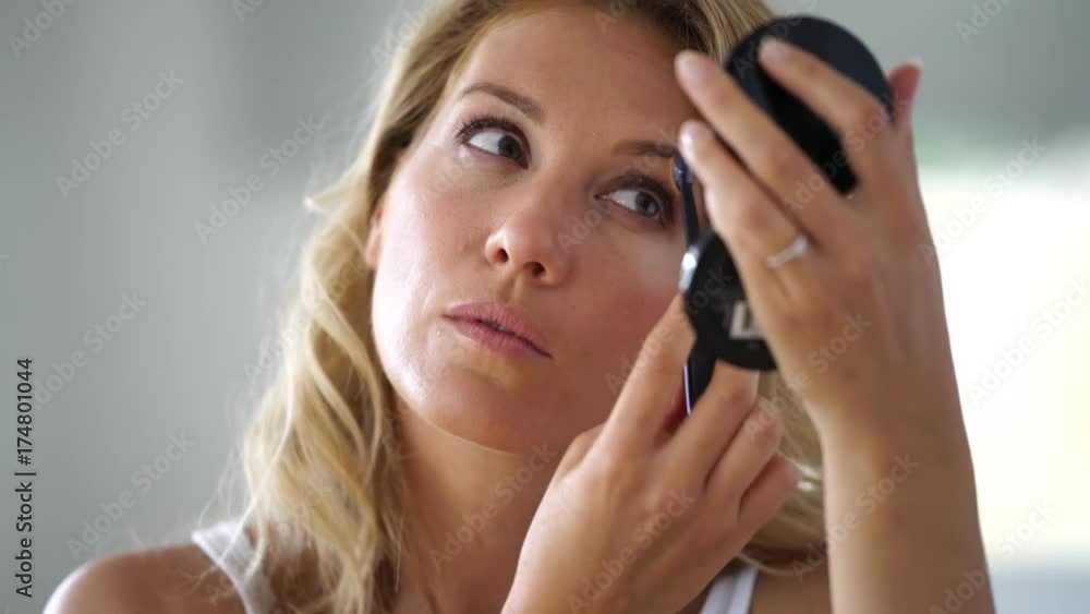 Portrait of attractive blond woman putting makeup on Portrait of attractive blond woman putting makeup on