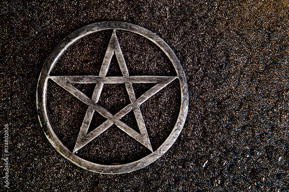 Obraz premium Gray metal pentagram on slate background with water drops