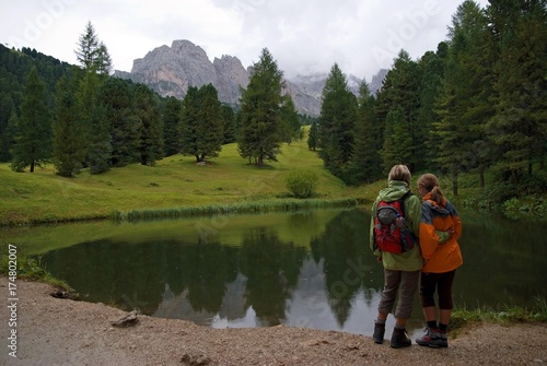 Mother and child at a small lake on the Seceda High Plateau with a view towards the Geisler mountains, Puez-Geisler National Park, Wolkenstein, Alto Adige, Italy, Europe © imageBROKER