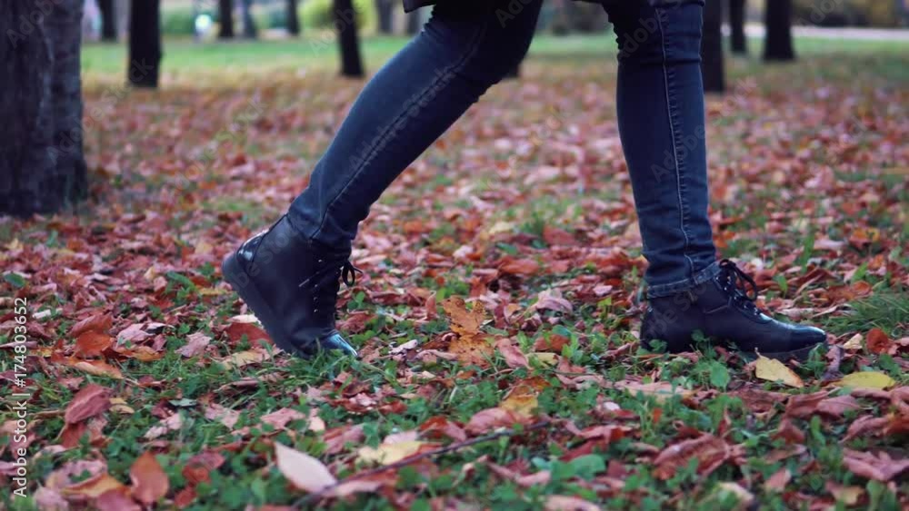 young woman walking in the autumn Park. female feet closeup. girl walking on fallen leaves. young woman walking in the autumn Park. female feet closeup. girl walking on fallen leaves.