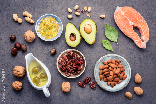Selection food sources of omega 3 and unsaturated fats. Superfood high vitamin e and dietary fiber for healthy food. Almond ,pecan,hazelnuts,walnuts,olive oil,fish oil and salmon on stone background.