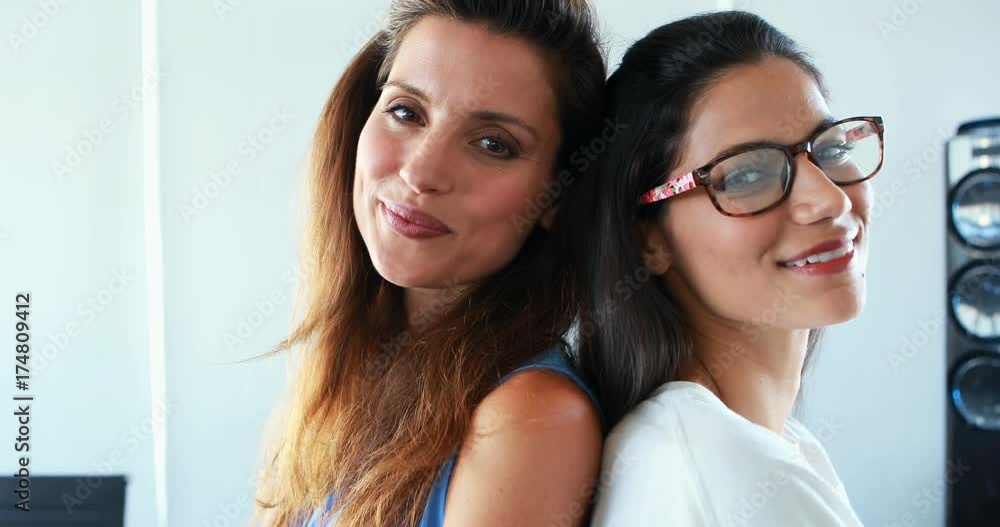 Portrait of female executives standing back to back Portrait of female executives standing back to back