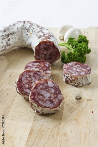 Gourmet salami, premium salami with garlic and parsley on a wooden board