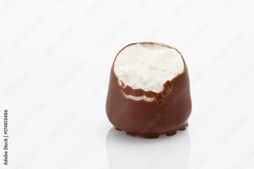 A bite taken from a chocolate-coated marshmallow treat A bite taken from a chocolate-coated marshmallow treat