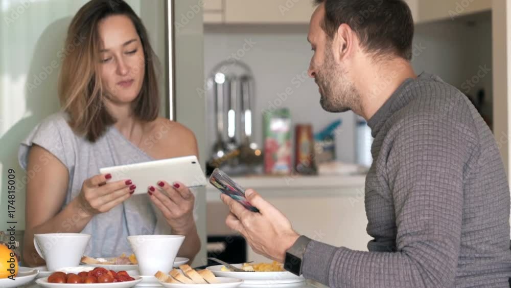 Couple with tablet computer and smartphone talking during breakfast at home
Couple with tablet computer and smartphone talking during breakfast at home