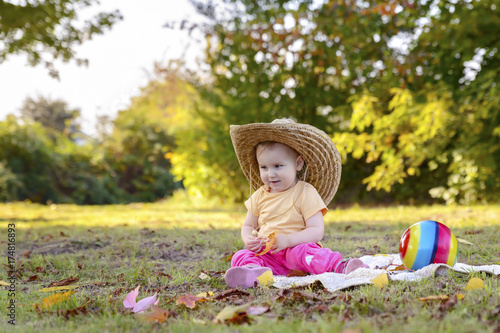Beautiful happy girl in a big hat on a sunny meadow  © igorgeiger