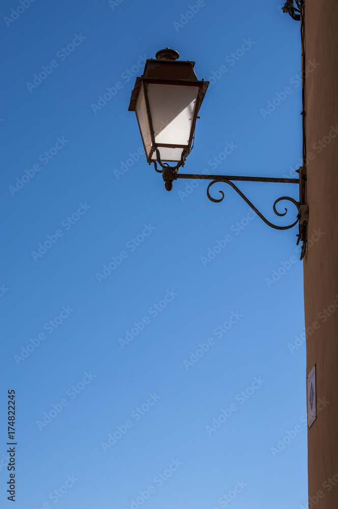 Bonifacio, Corsica: arredo urbano e architettura cittadina, un lampione in ferro battuto e un cielo azzurro sullo sfondo